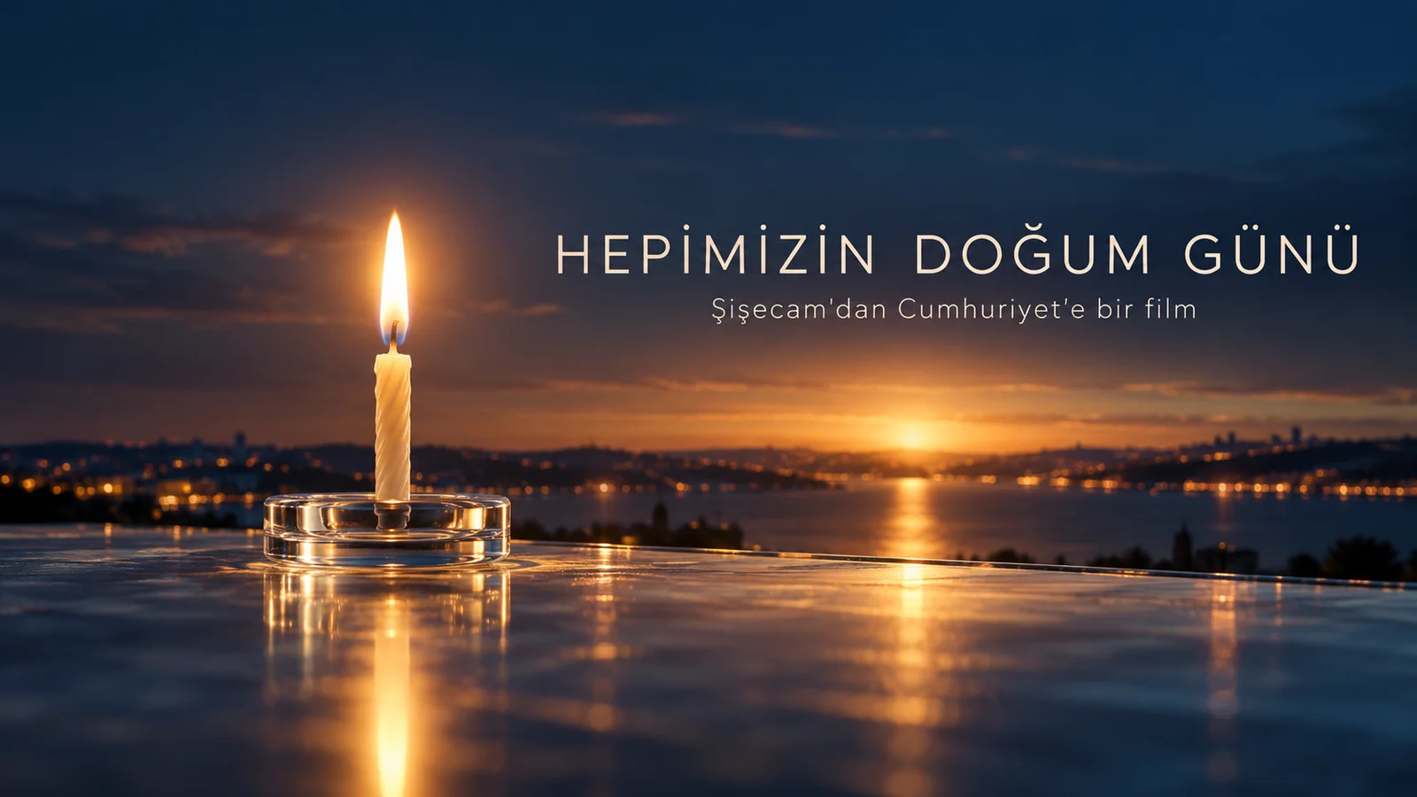 Cam yüzeyde yanan tek mum ve gün batımı, Hepimizin Doğum Günü başlıklı editoryal kapak